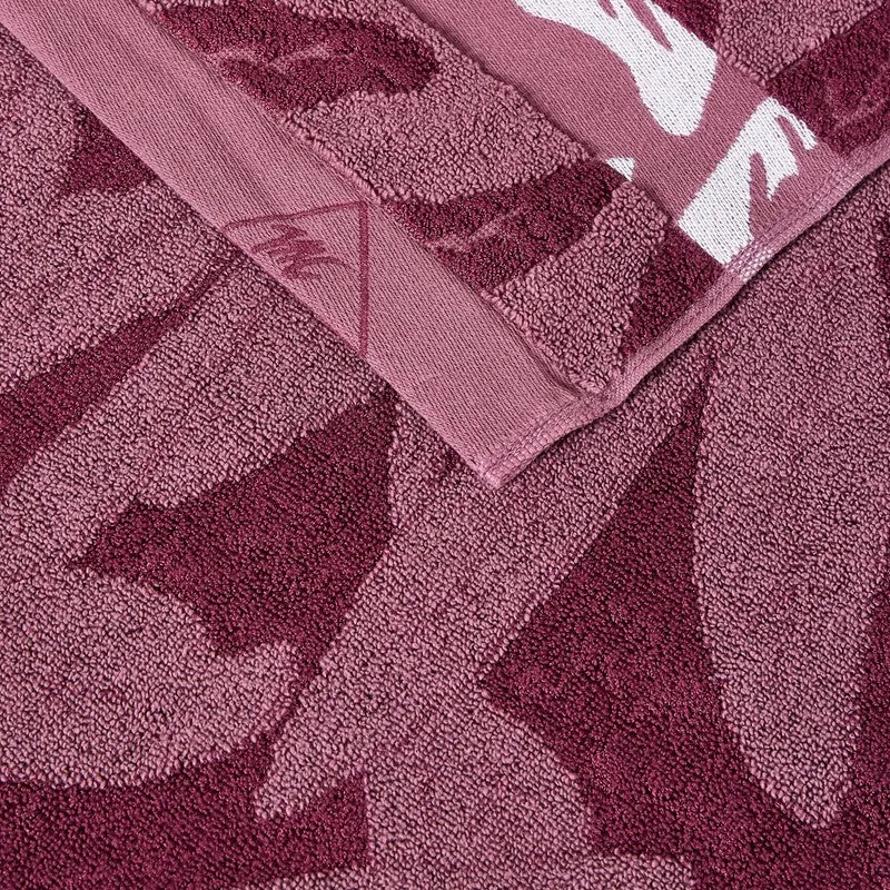 Close-up of the towel border and maroon floral textured fabric.