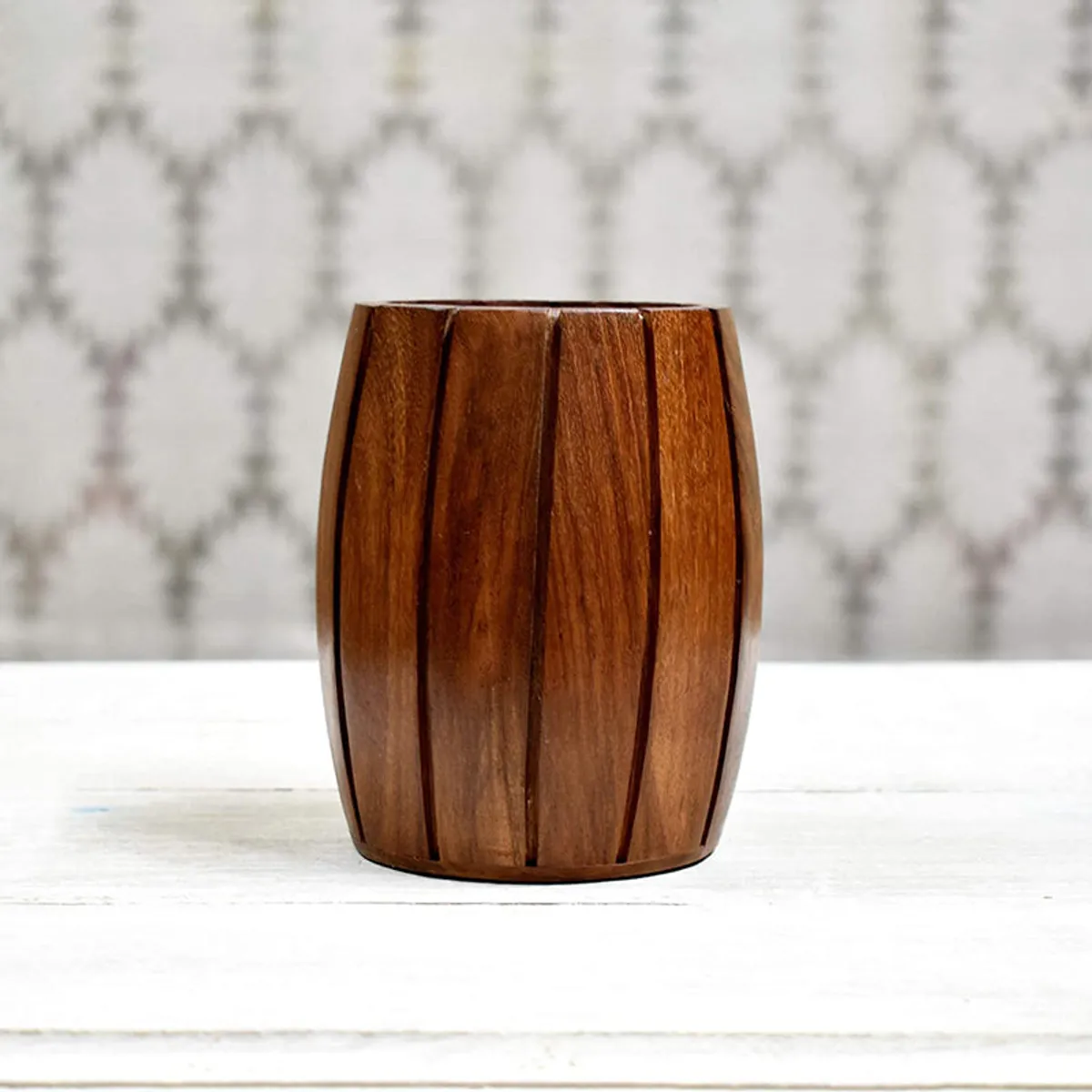 Empty brown barrel-shaped wooden holder with deep vertical grooves