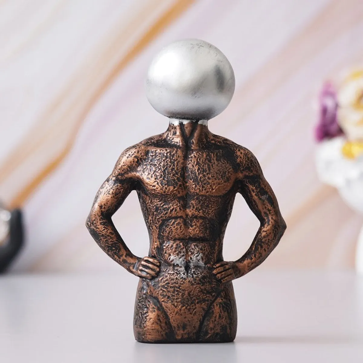 Decorative figurine showpiece with metallic silver head on textured torso