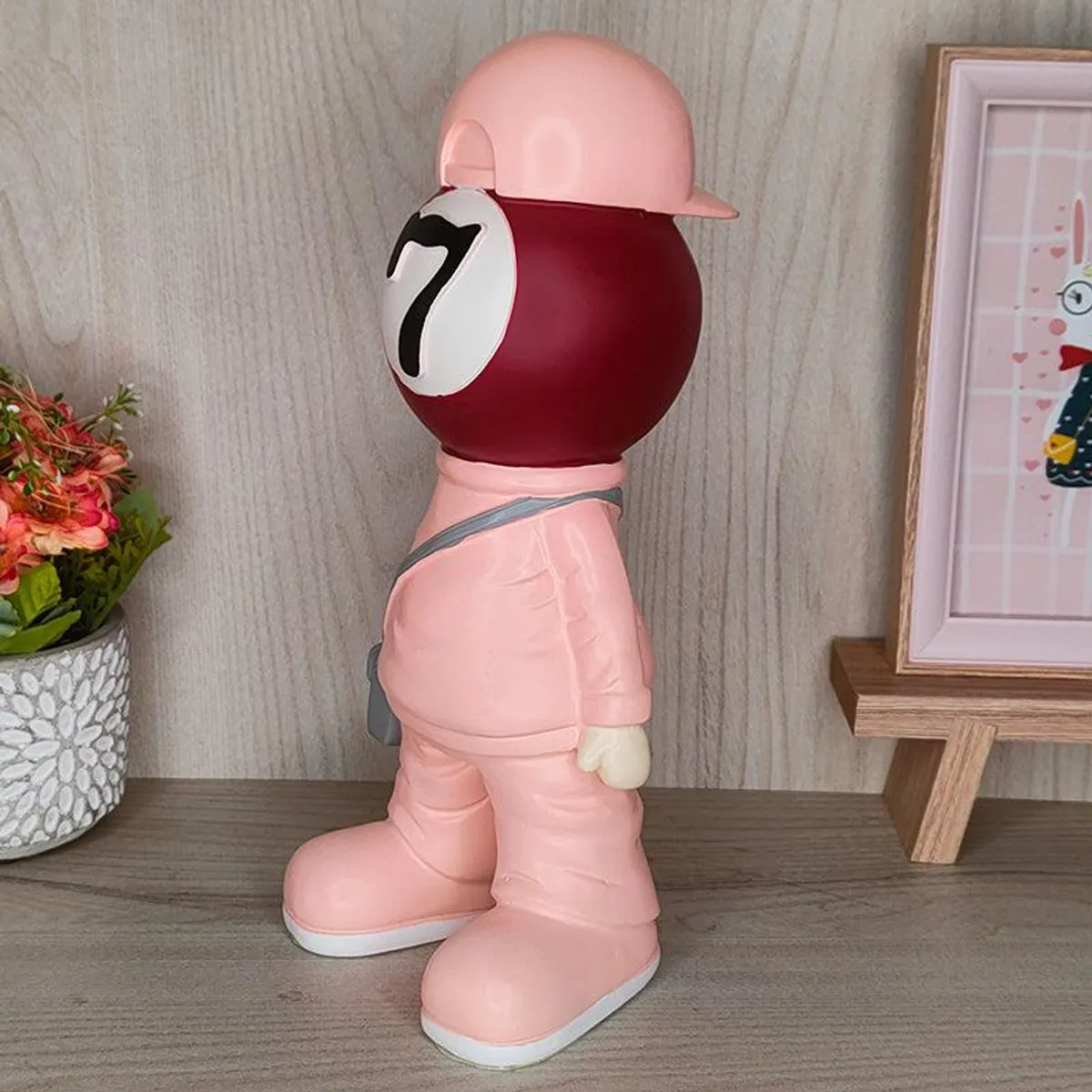 Side view of a pink figurine showpiece with a red billiards-ball head and cap