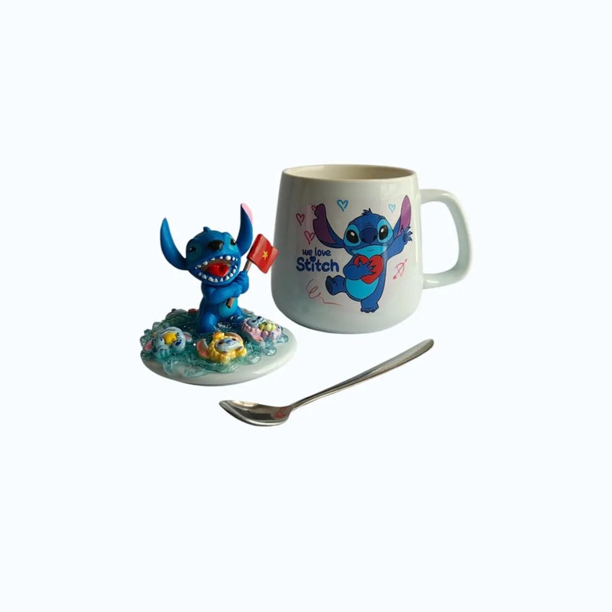 Cartoon character mug shown with decorative lid and metal spoon