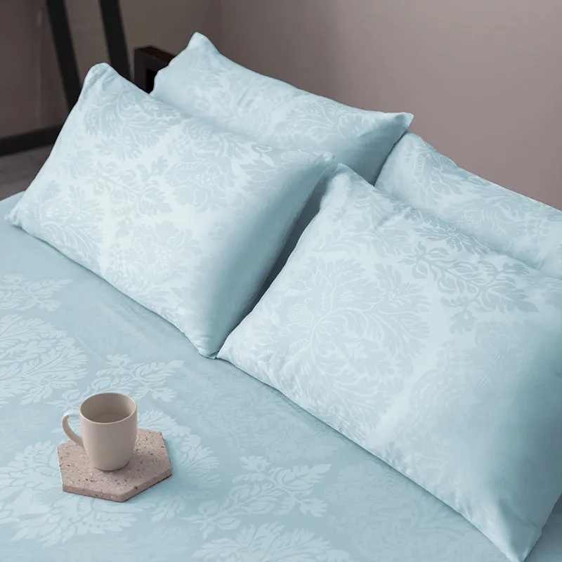 Matching pale blue pillow covers placed on the floral bedsheet