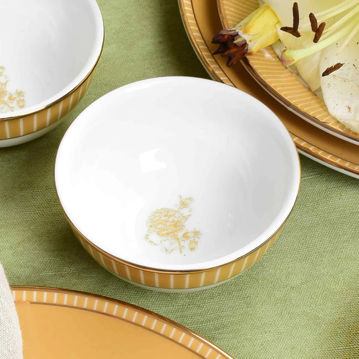 White porcelain veggie bowl with mustard striped exterior and gold floral motif