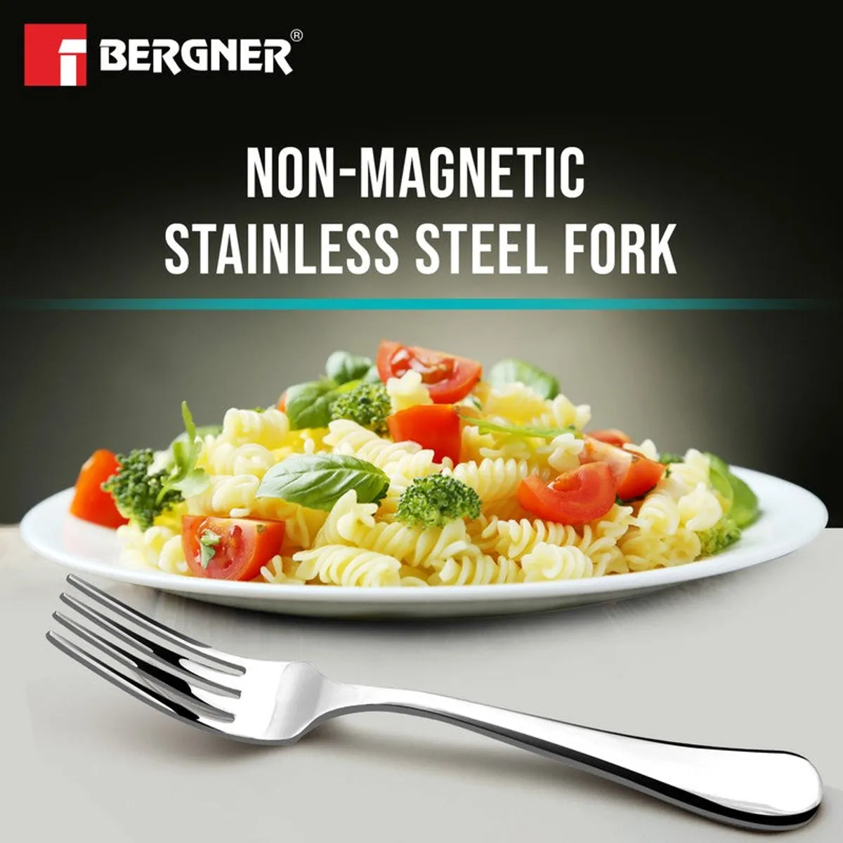 Polished silver fork beside a plate of pasta on a grey surface