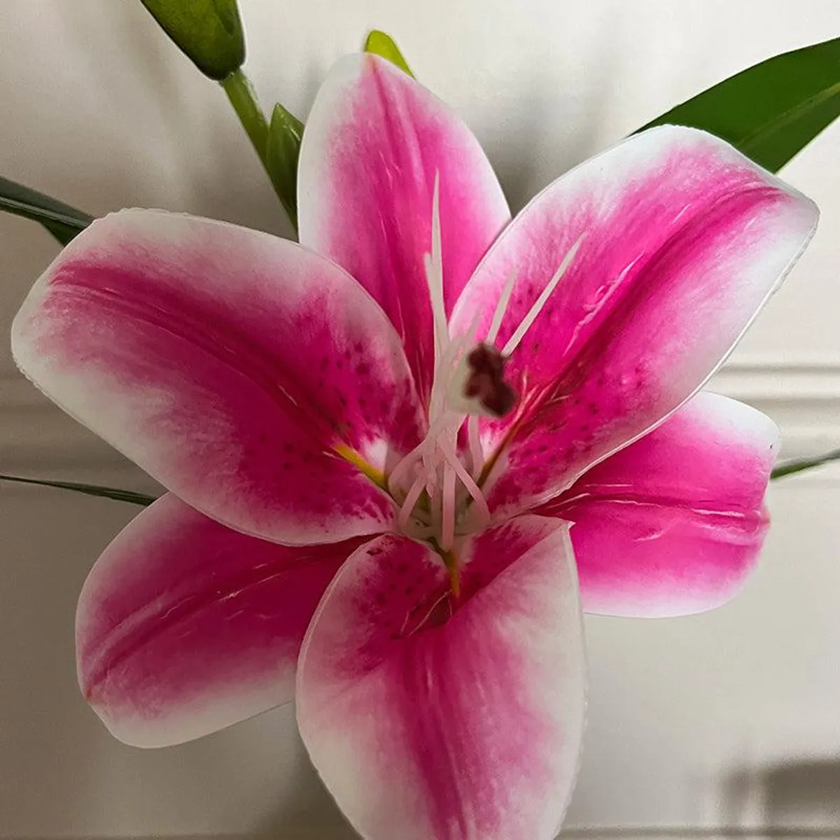 Close-up of the faux lily's pink petals with white edges and detailed centre.