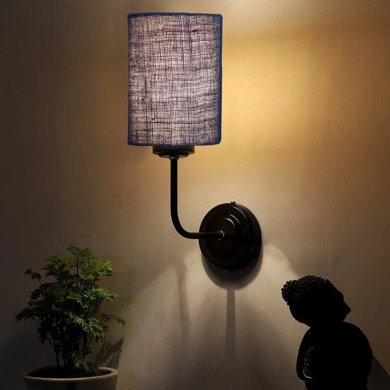 Blue jute wall lamp casting warm light upward on a wall