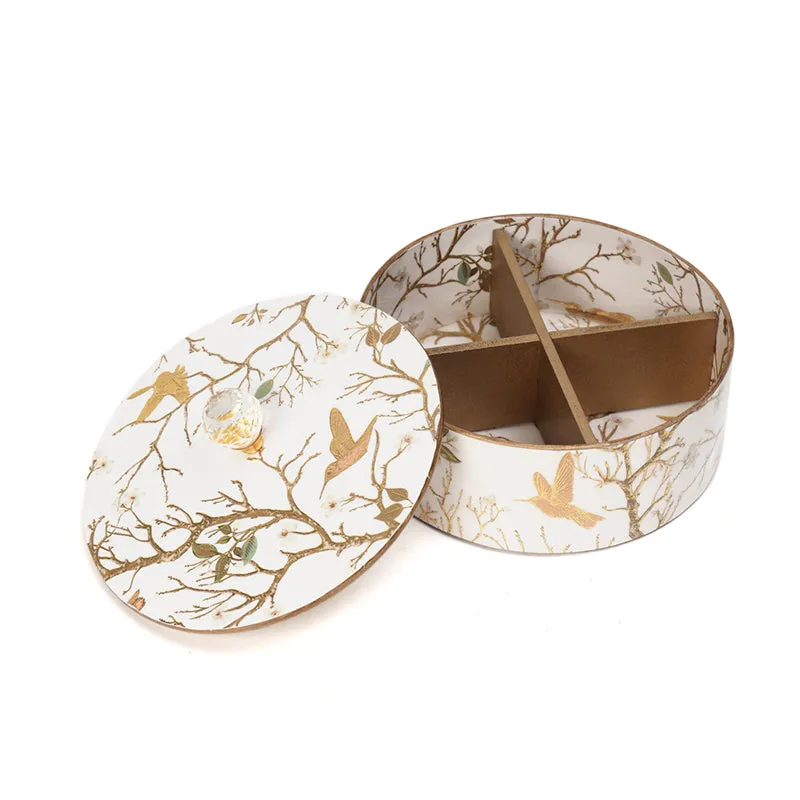 Open round box showing four interior compartments and a matching decorated lid
