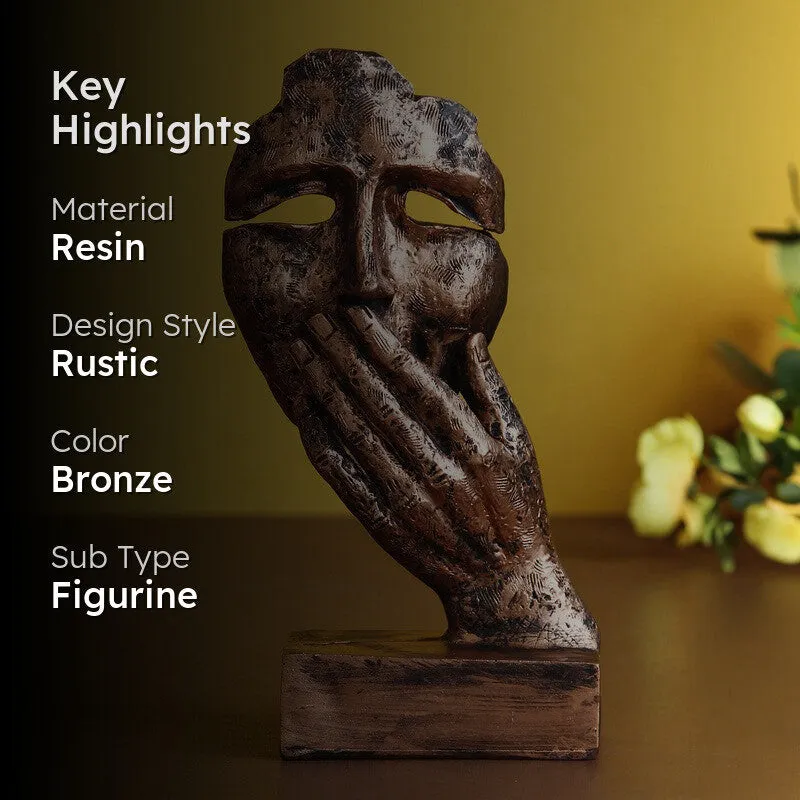 Bronze abstract mask figurine displayed against a warm background