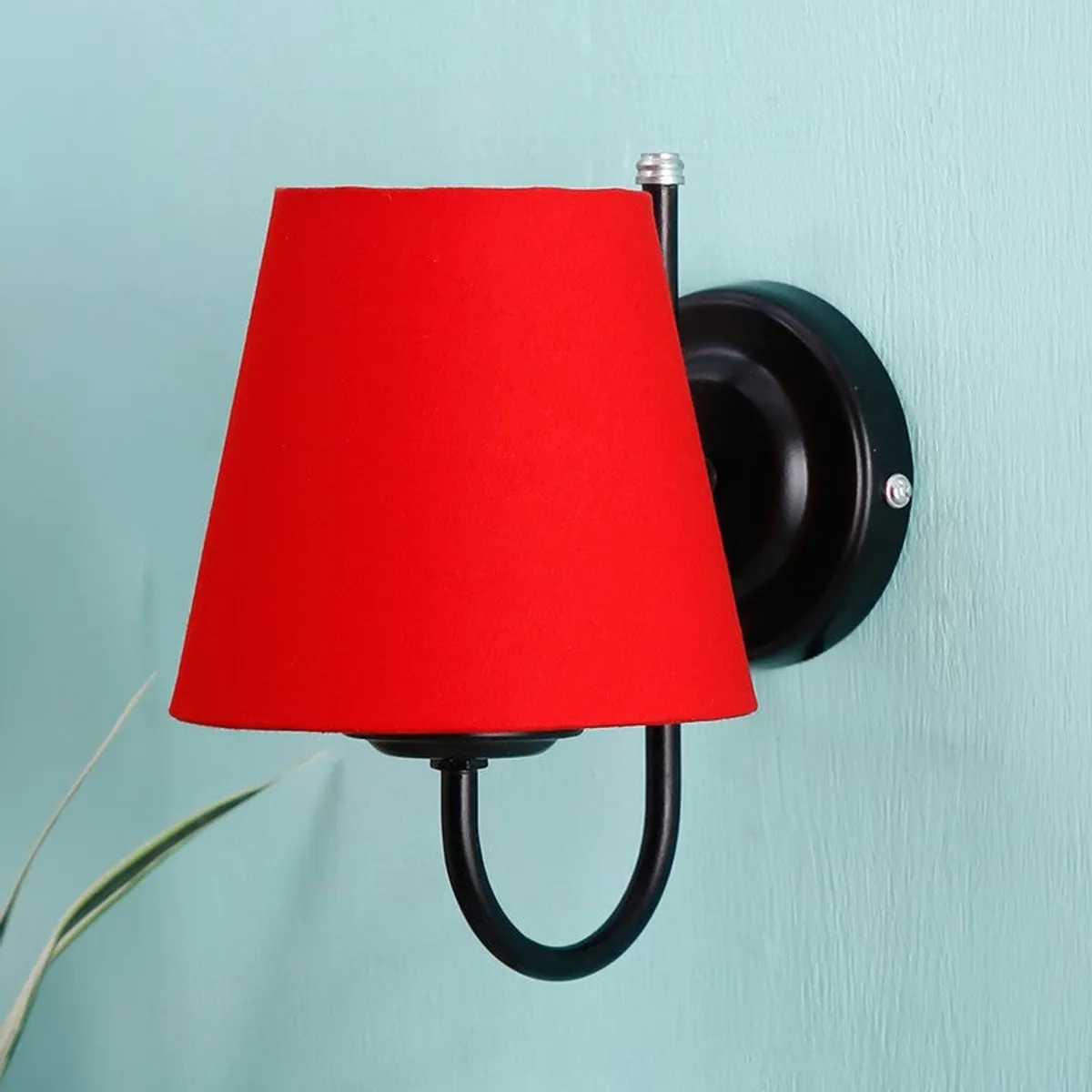 Red wall-mounted lamp with tapered shade and black arm