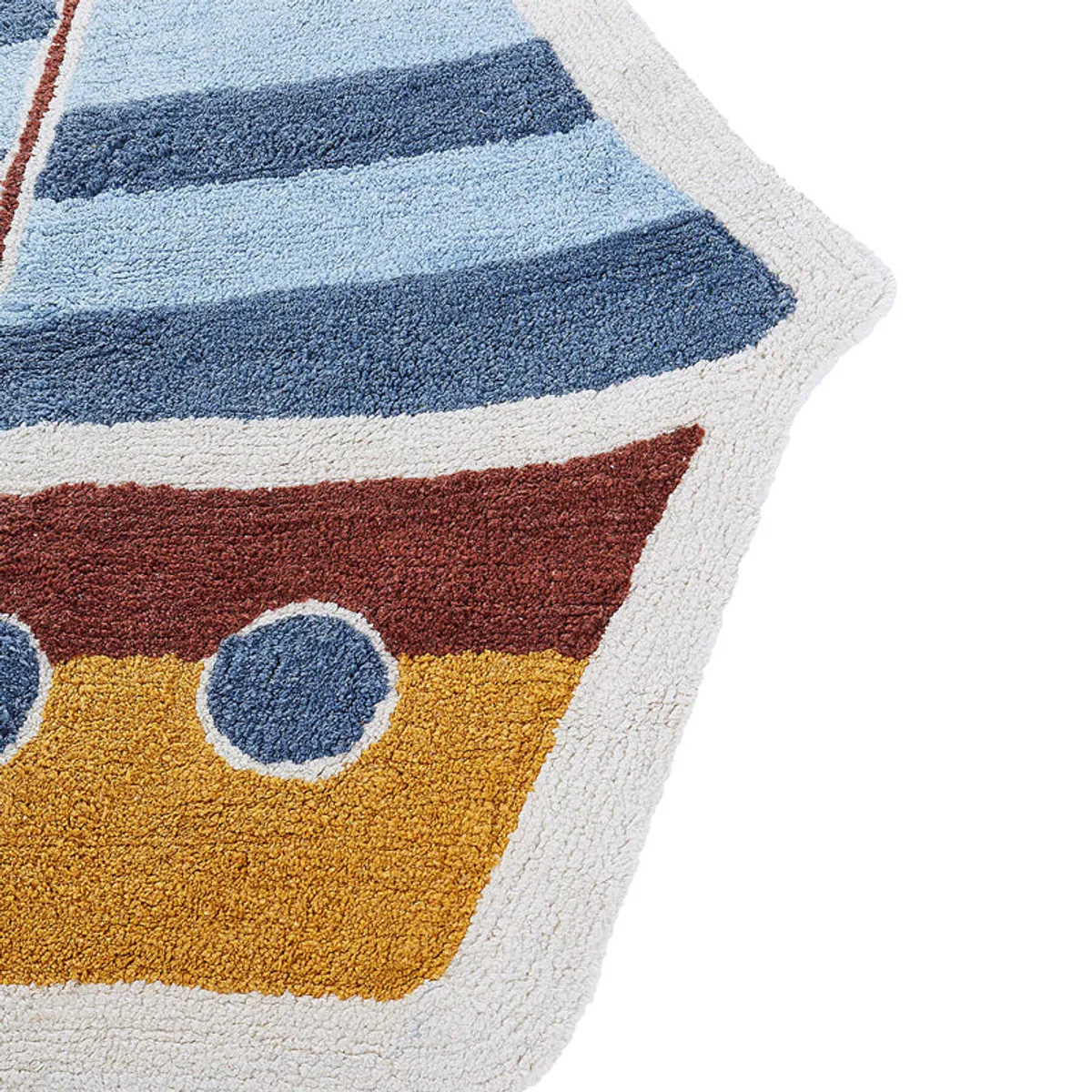 Close-up of the sailboat rug showing its textured blue sail and rust and yellow boat details.