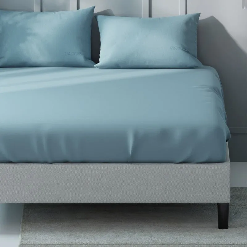 Close view of a blue cotton bedsheet draped over a bed with matching pillows