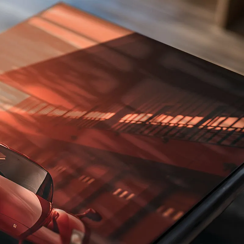 Close-up of car poster showing red sports car near a modern building