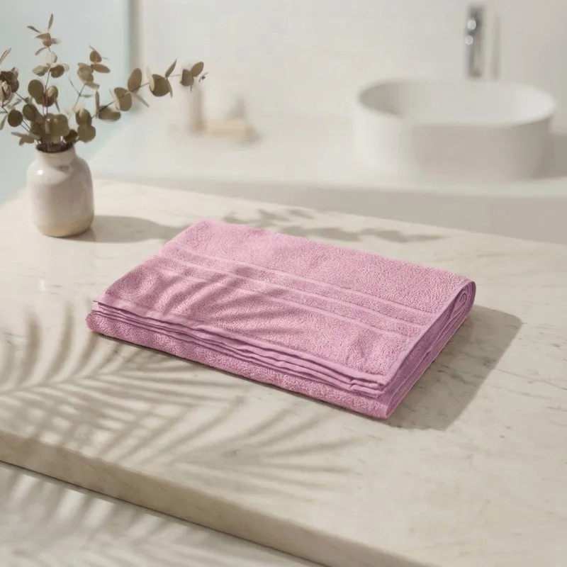 Folded light pink bath towel on a bathroom counter