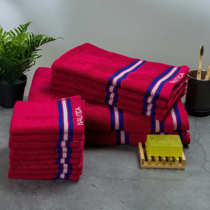 Folded pink striped towels arranged beside bathroom accessories and a plant.