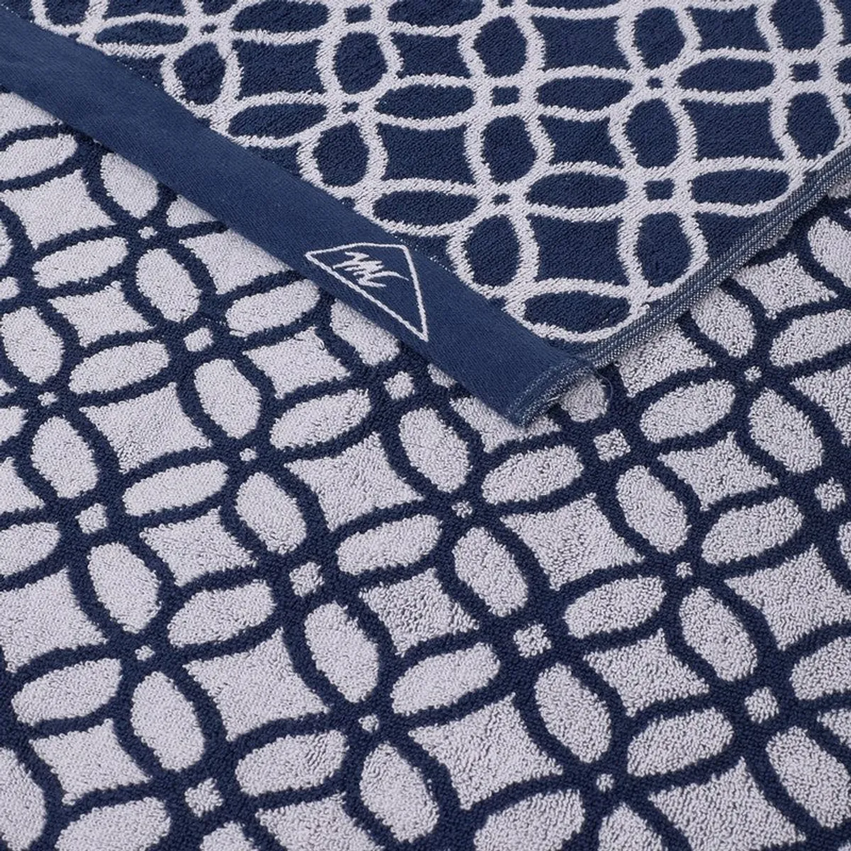 Close-up of overlapping blue and white patterned towels with finished edges