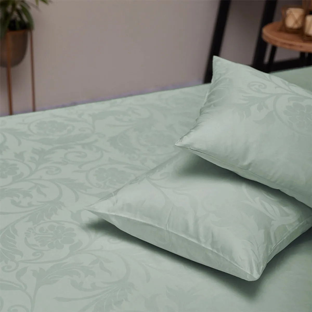 Sage green patterned duvet cover and pillows on a bed