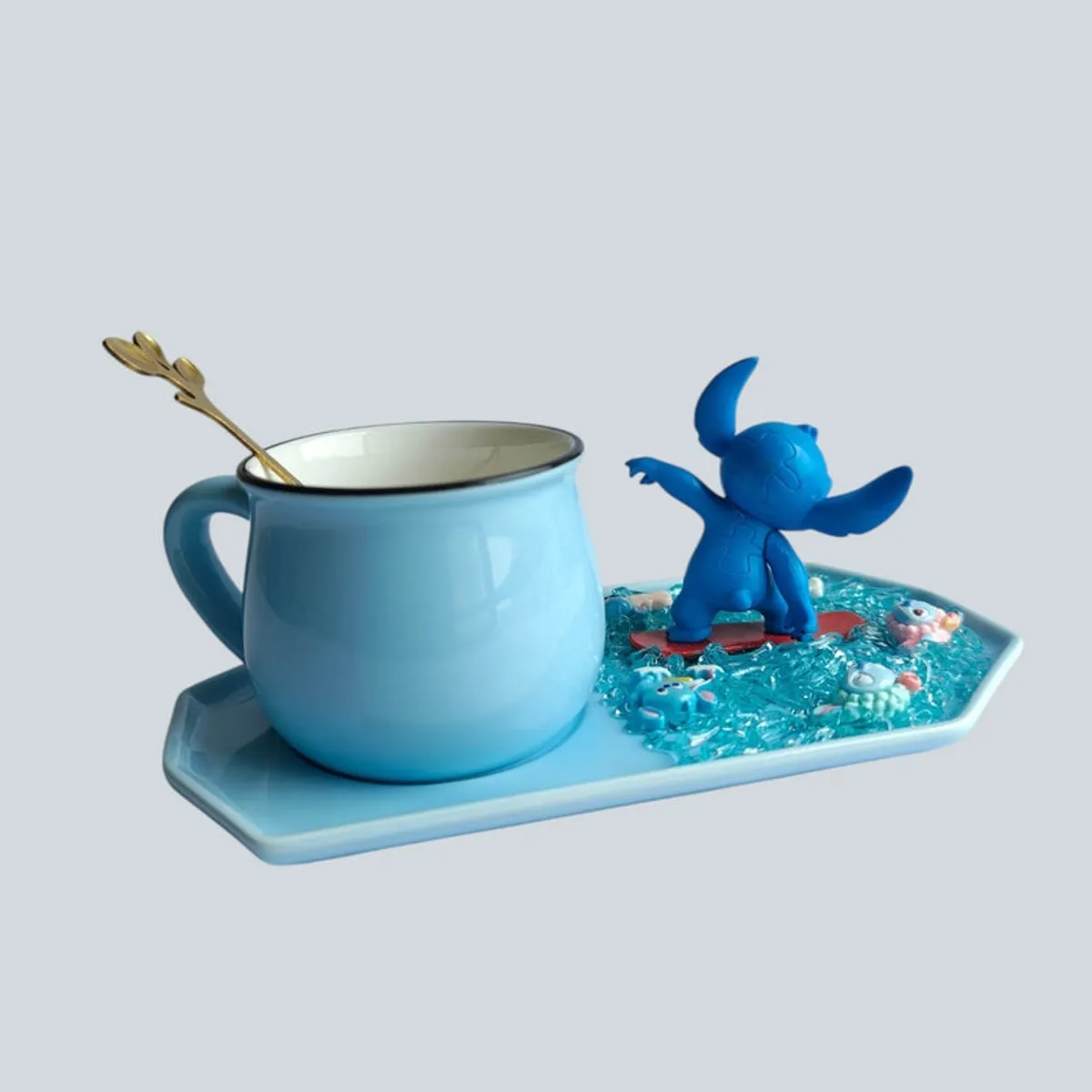 Side view of a blue ceramic mug and character figurine arranged on a textured blue tray