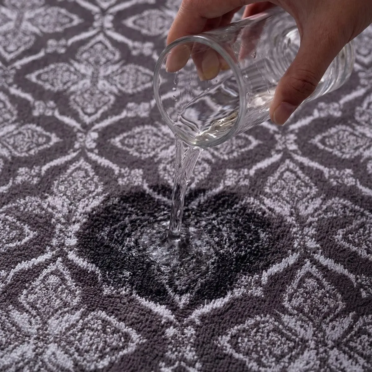 Water being poured onto the absorbent textured grey floral towel