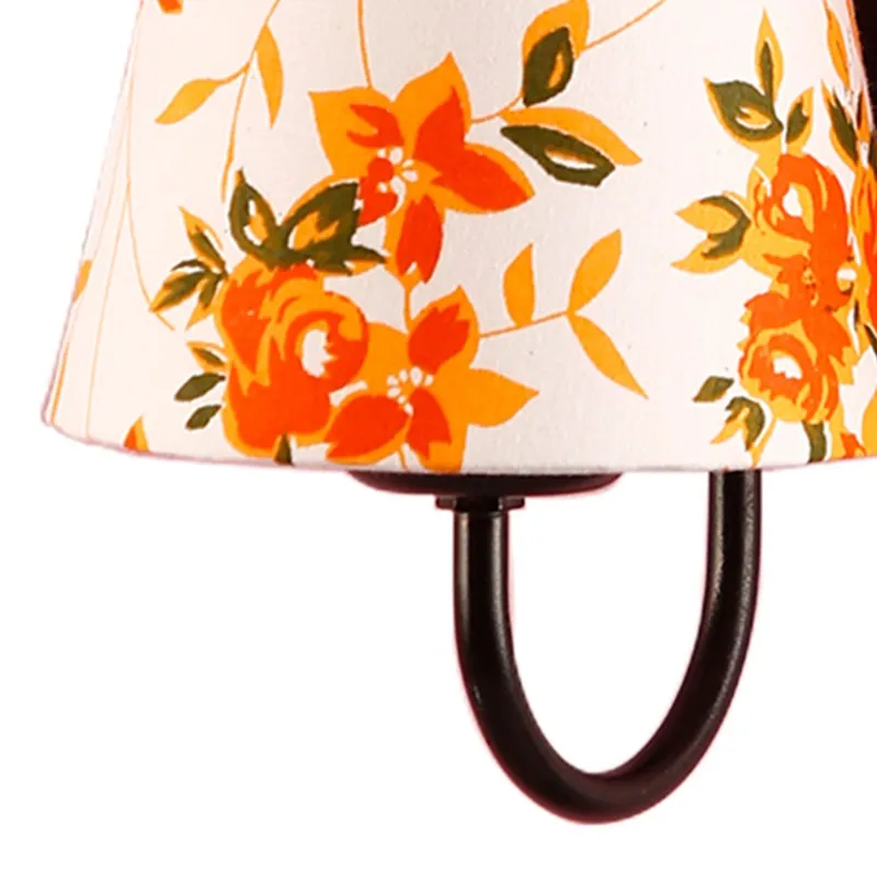 Close-up of orange floral cotton shade and dark metal arm