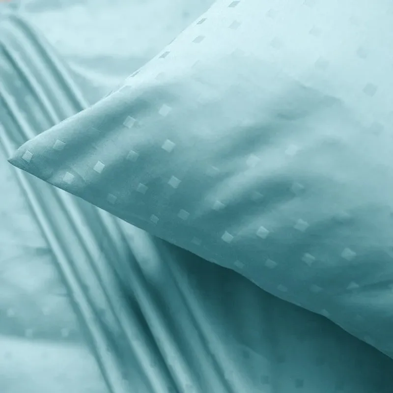 Close-up of the sky-blue bedsheet showing its small geometric dot pattern