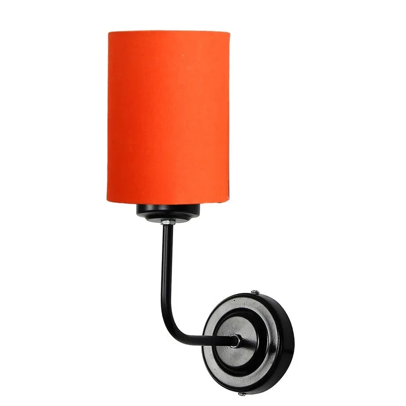 Angled view of orange cotton wall lamp with black iron base