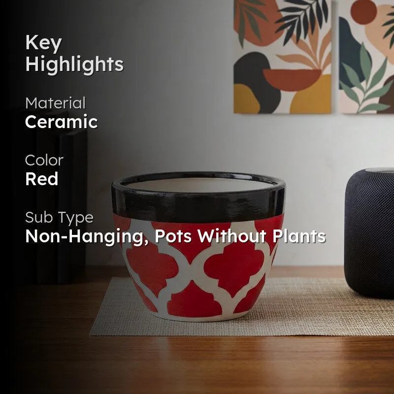 Red ceramic pot with white pattern and black rim in a styled room setting