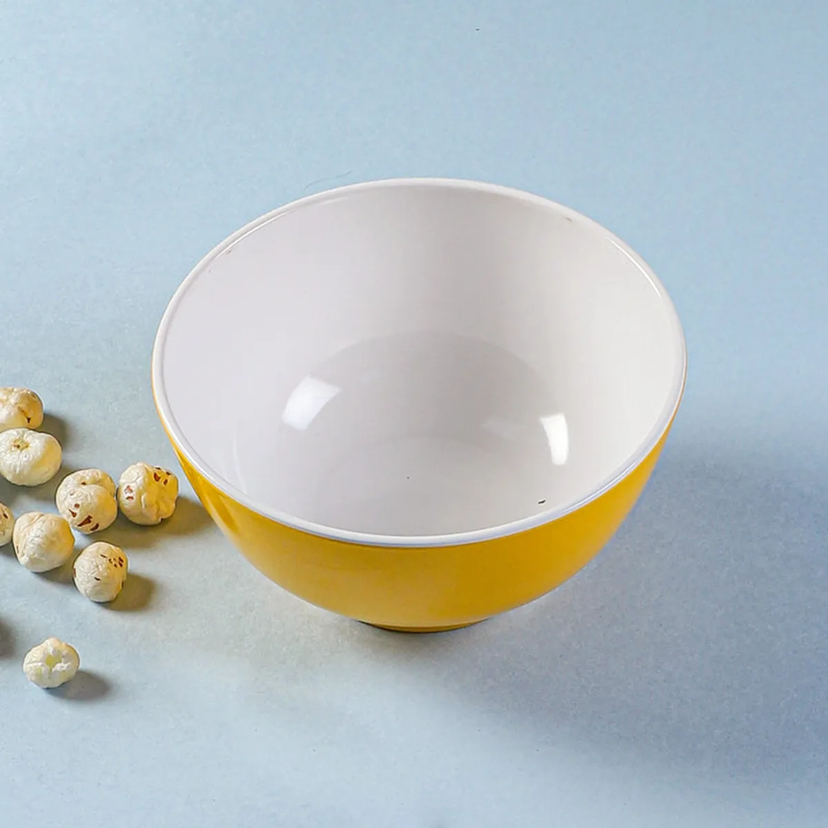 Yellow and white bowl shown from the front on a blue background.