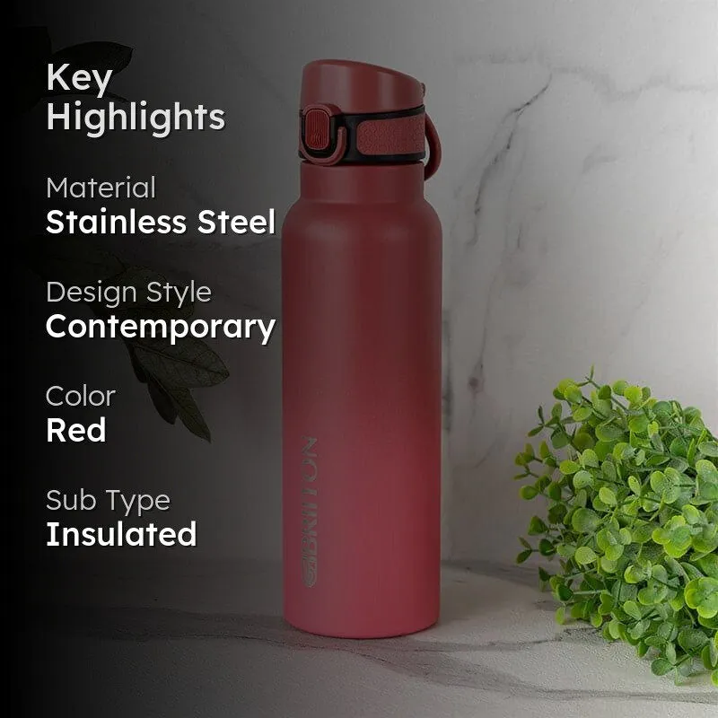 Red insulated bottle styled against a light backdrop with greenery