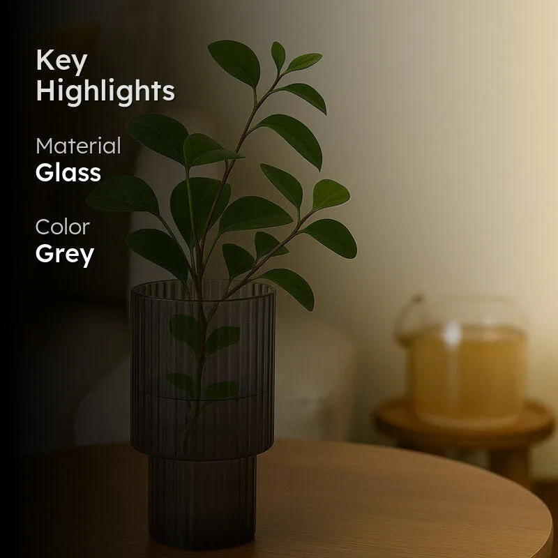 Grey glass vase with leafy stems and key highlight overlay
