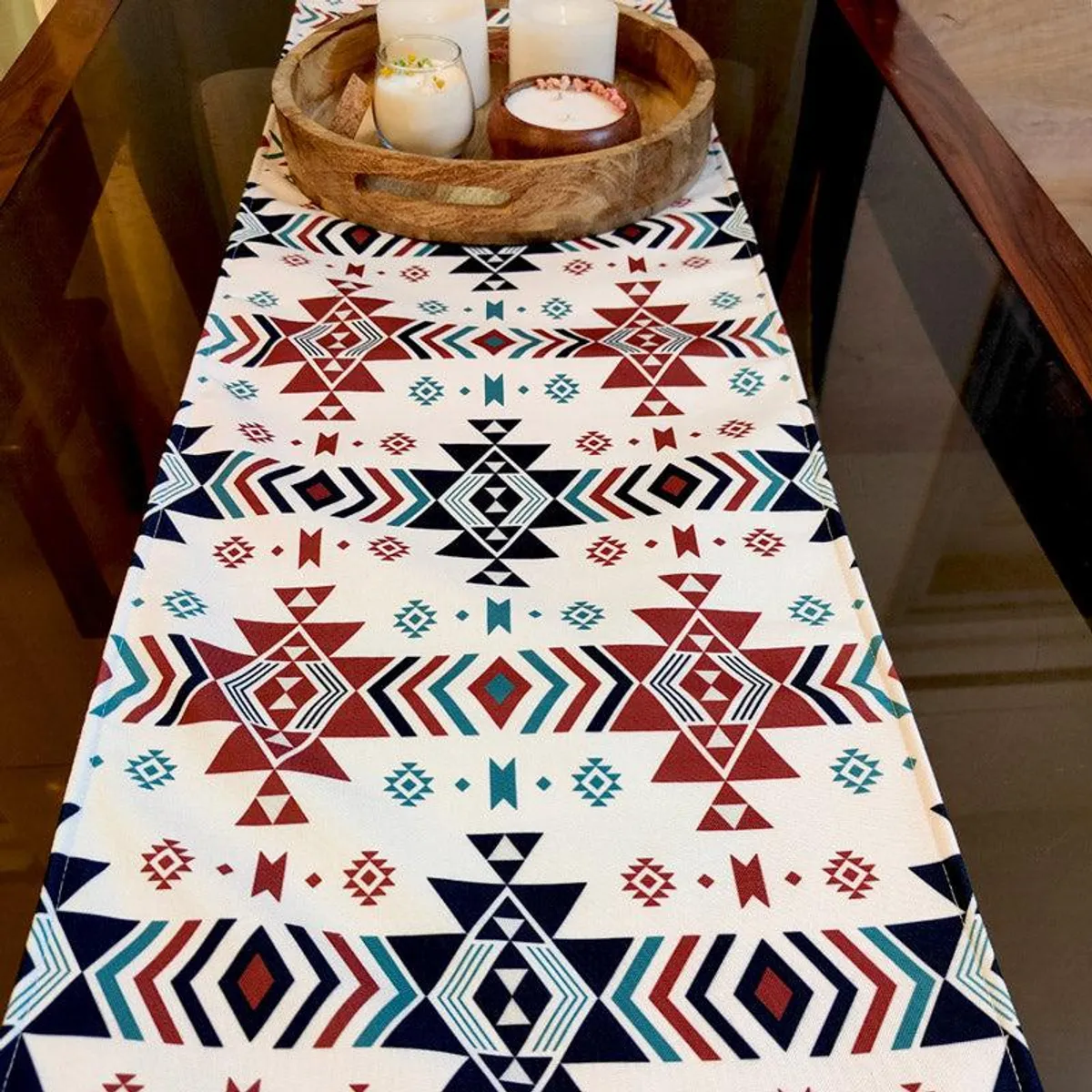 Geometric table runner styled with a wooden tray and candles on a dining table