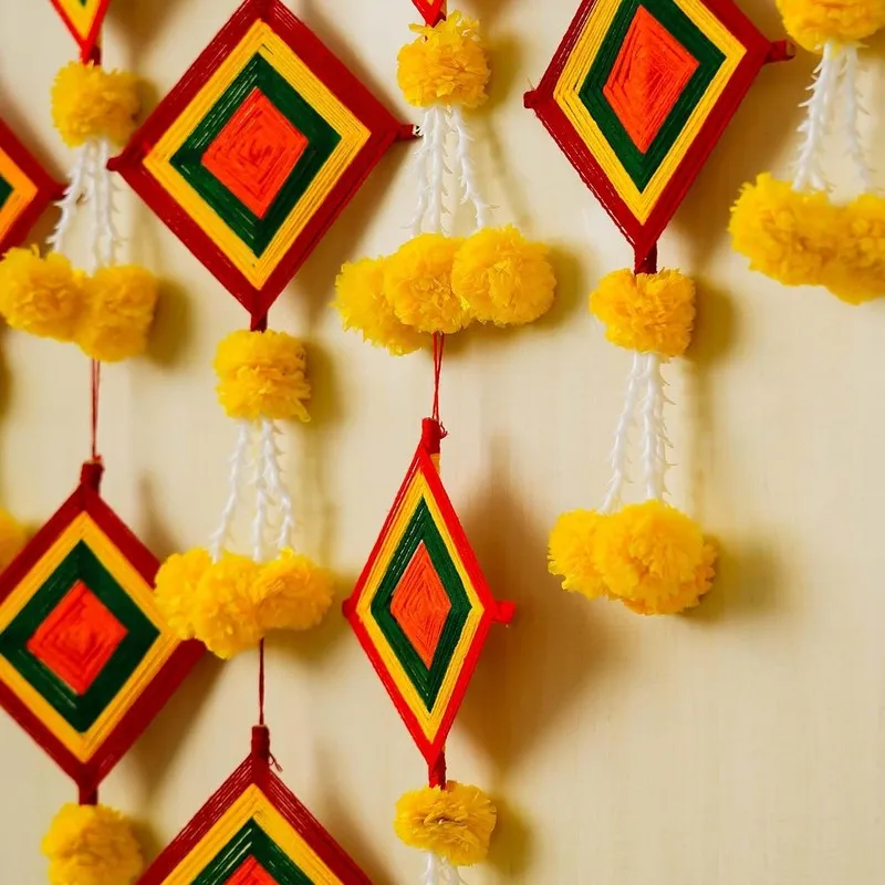 Close-up of several multicolour hanging latkans with yellow pom-poms