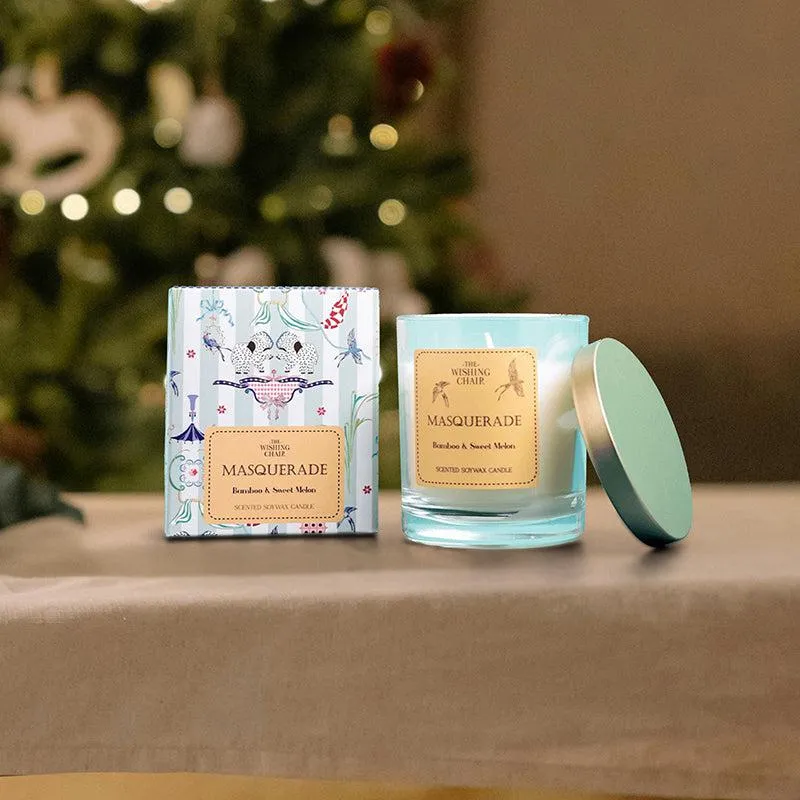 Scented candle in an aqua glass jar with lid beside a printed box