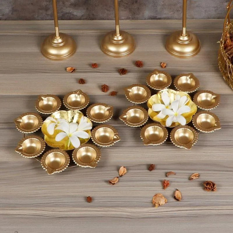 Gold urli set arranged with petal-shaped diyas around flower-shaped centres