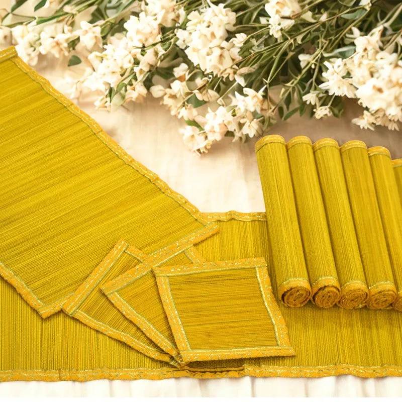 Close-up of yellow table mat fabric, zari edging and rolled mats