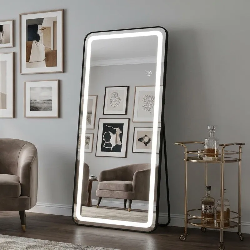 Illuminated black-framed mirror leaning in a contemporary living room.