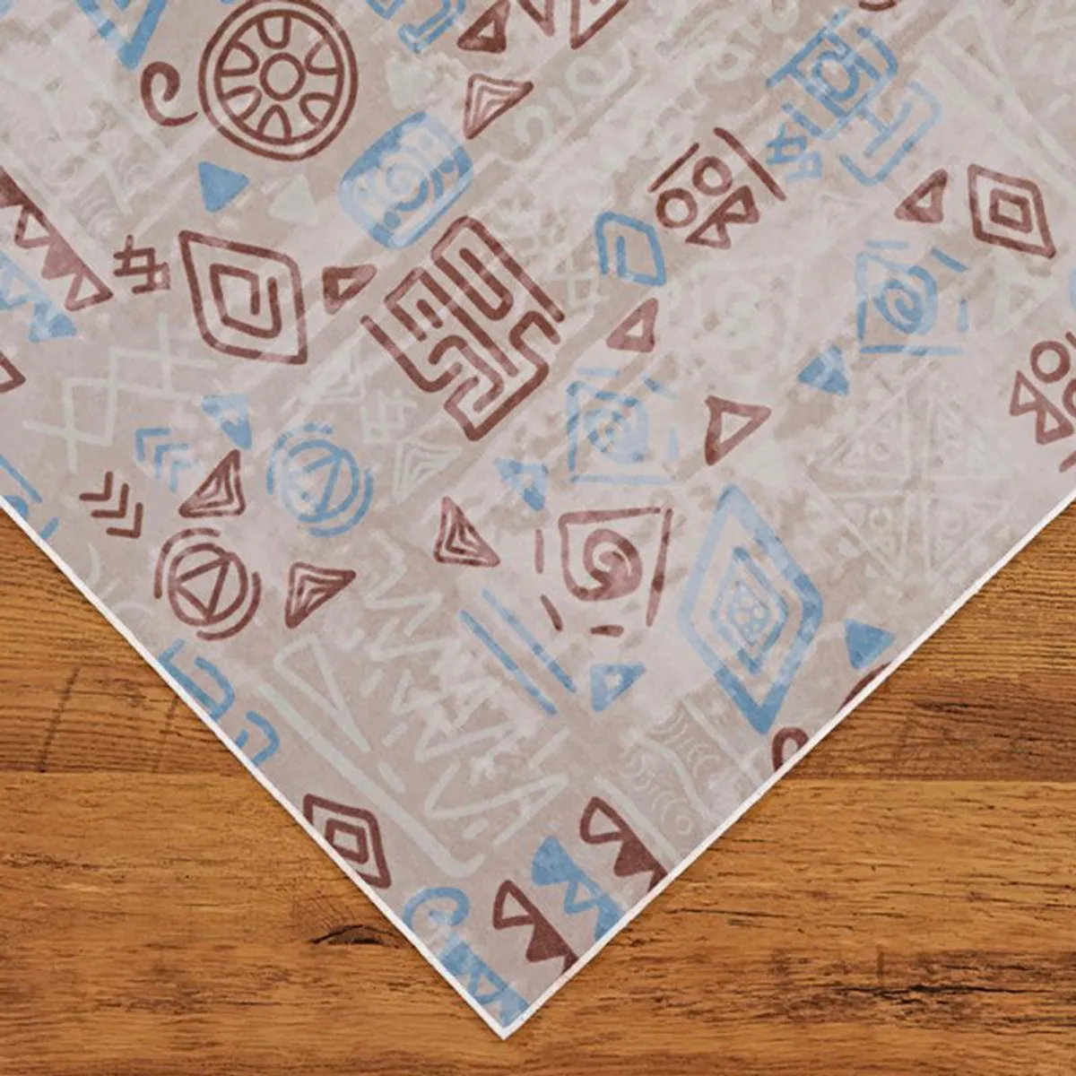 Corner of a beige carpet with scattered brown and blue geometric motifs