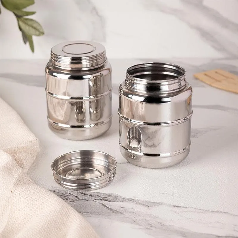 Two glossy silver cylindrical storage containers with lids on a marble surface