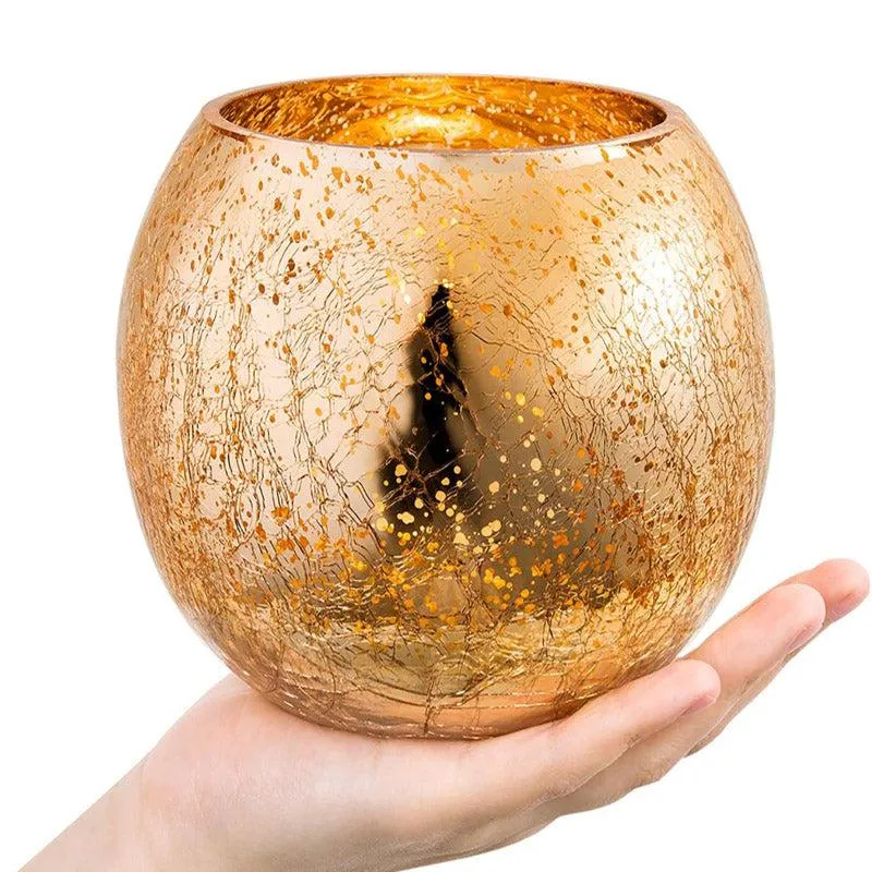 Close-up of a gold glass candle holder resting on an open hand