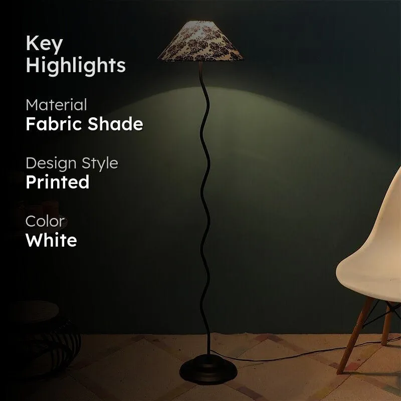 Lit floor lamp with floral shade shown in a dark styled interior