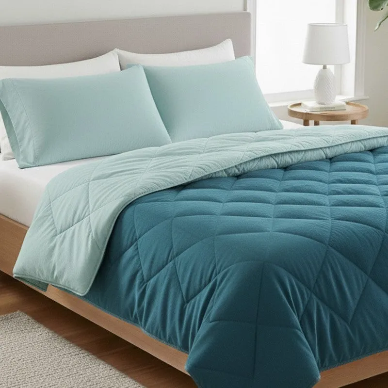 Close-up of the blue and pale teal quilted comforter on a bed