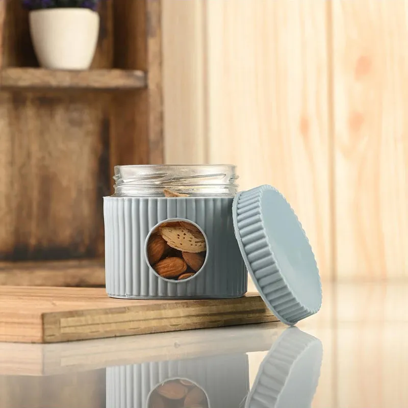 Open grey ribbed storage jar with its lid resting beside it