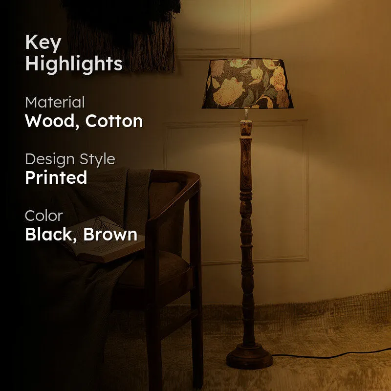 Lit wooden floor lamp with floral shade in a room setting
