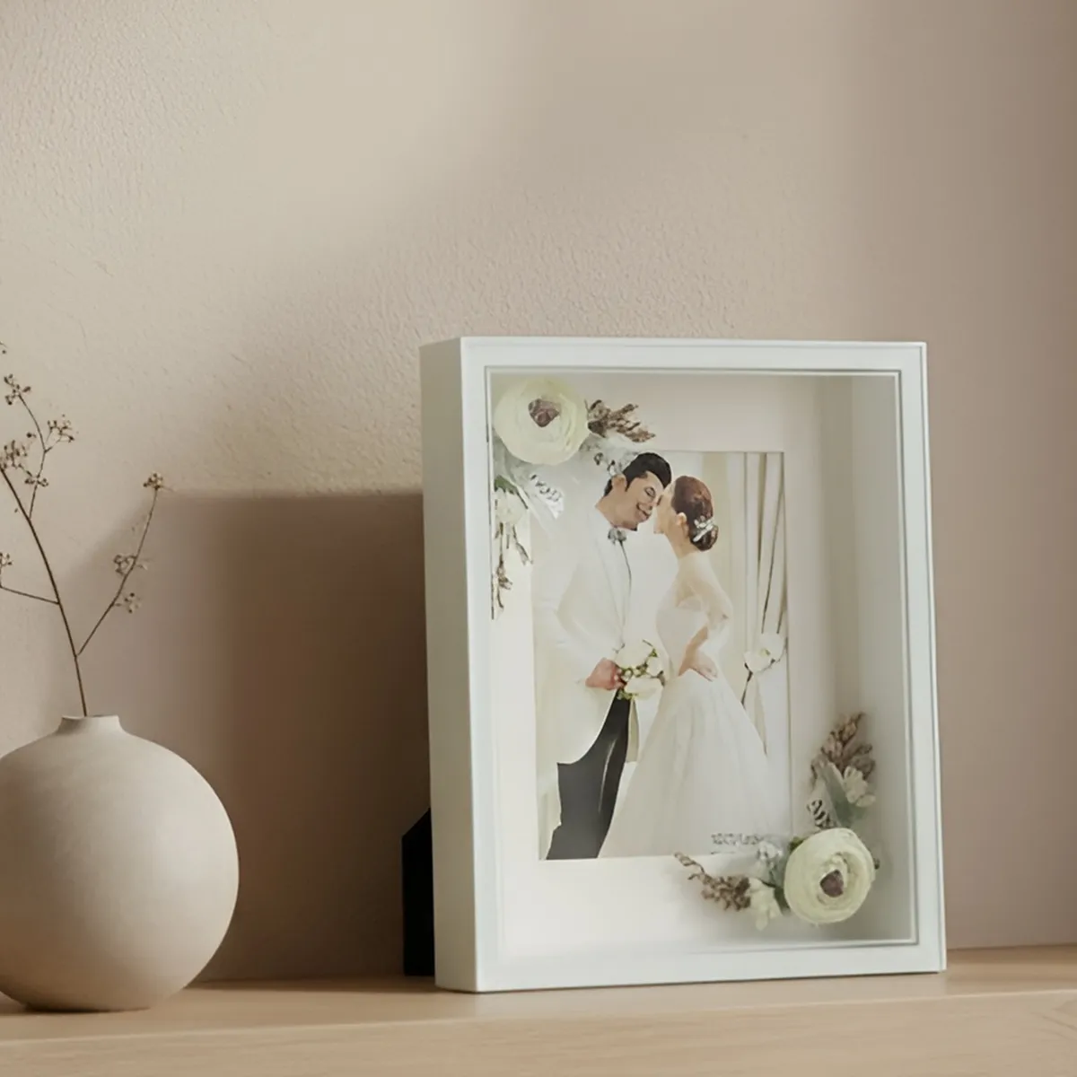 White rectangular frame with warm illuminated edges and a wedding photograph.
