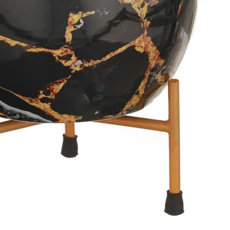 Close-up of black marbled planter with gold veining resting on a stand
