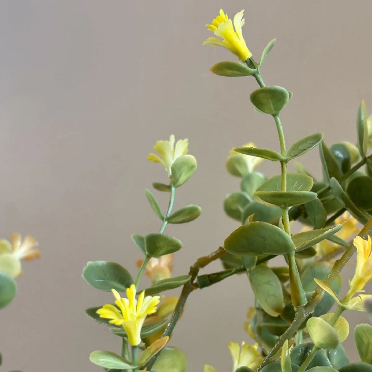 Close-up of yellow artificial flowers and green eucalyptus leaves