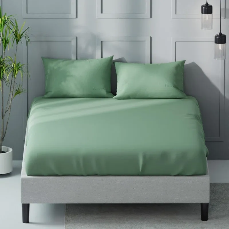 Front view of a green solid bedsheet and two matching pillows