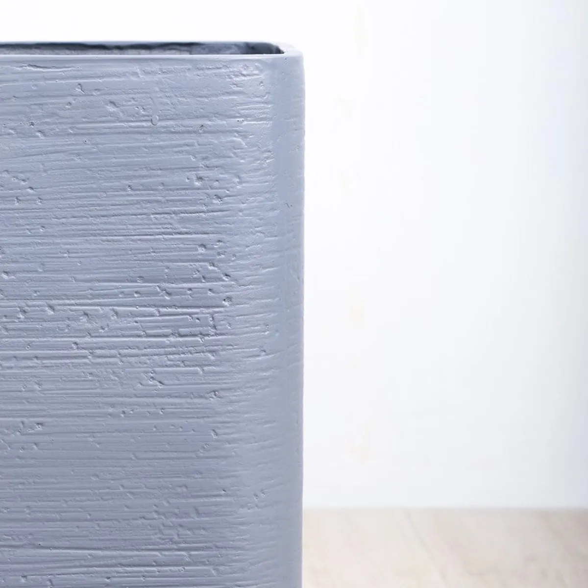 Close-up view showing the textured grey surface of the planter