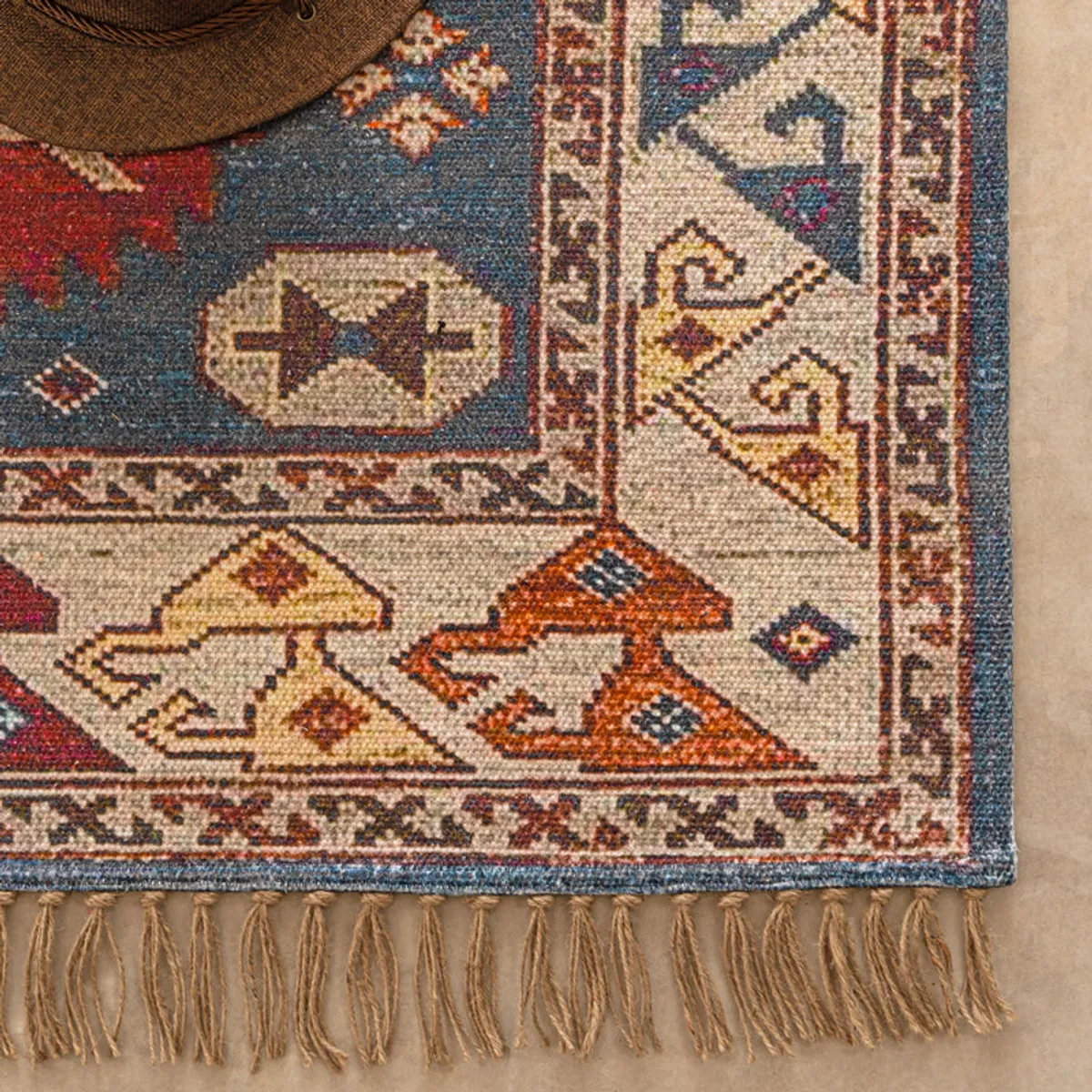 Detailed corner view showing the rug's patterned border and tassels