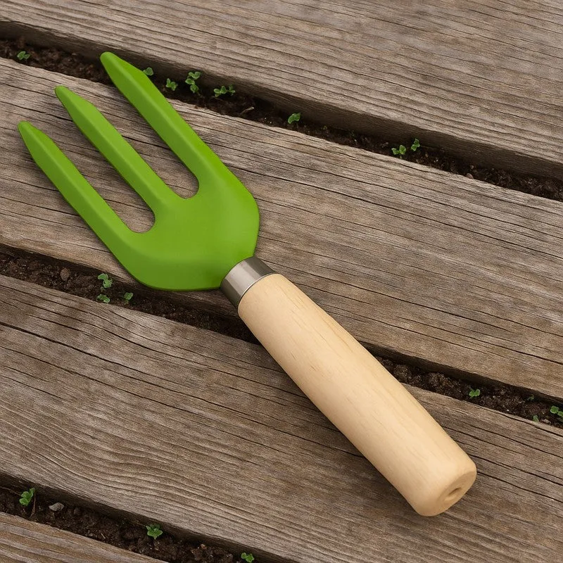 Green garden fork with a wooden handle placed across a raised garden bed