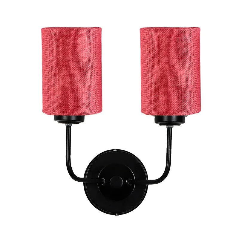 Studio view of pink dual-shade wall lamp with black round mount